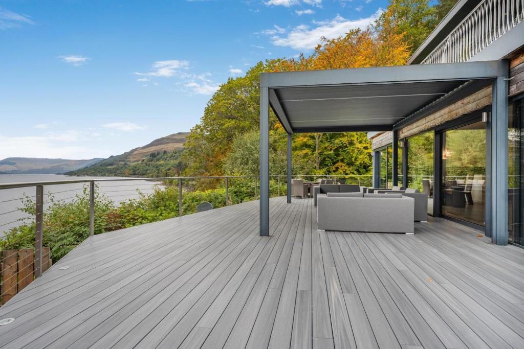 a wooden deck with a table and chairs on a house at 5 Bed in St. Fillans oc-t30058 in Saint Fillans