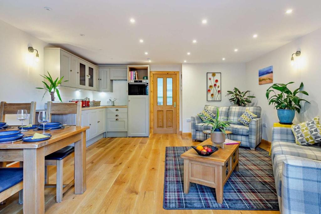 a living room with a table and a kitchen at 1 Bed in Strathpeffer oc-h30077 in Strathpeffer