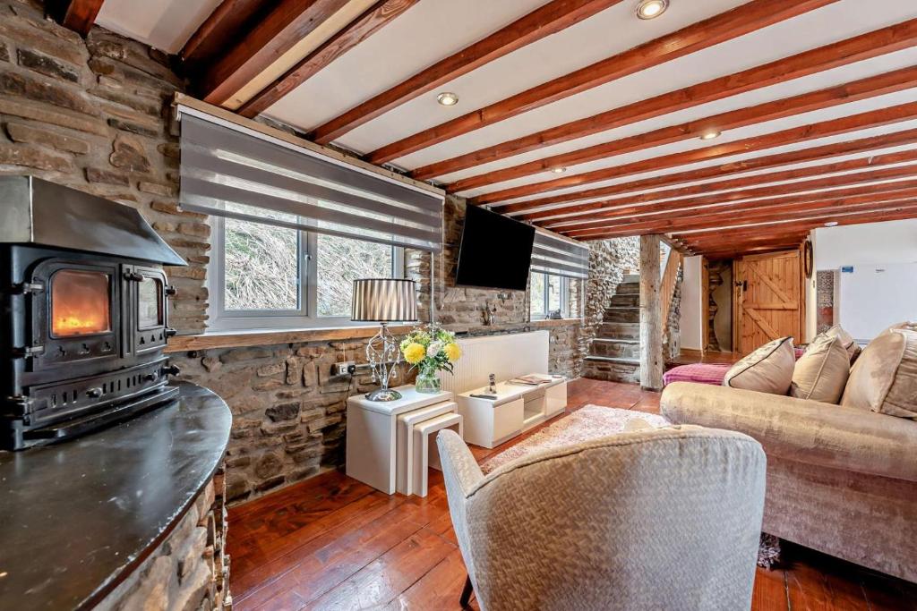 a living room with a fireplace and a stone wall at 2 Bed in Port Talbot oc-b30705 in Port Talbot