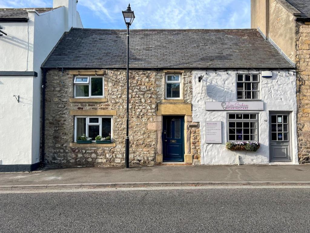 a stone building with a blue door on a street at 1 Bed in Corbridge oc-t31977 in Corbridge