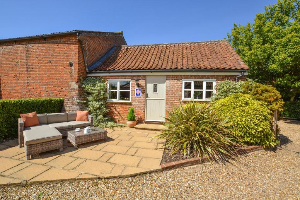 a brick house with a patio and a white door at 1 Bed in Swannington oc-1011 in Alderford