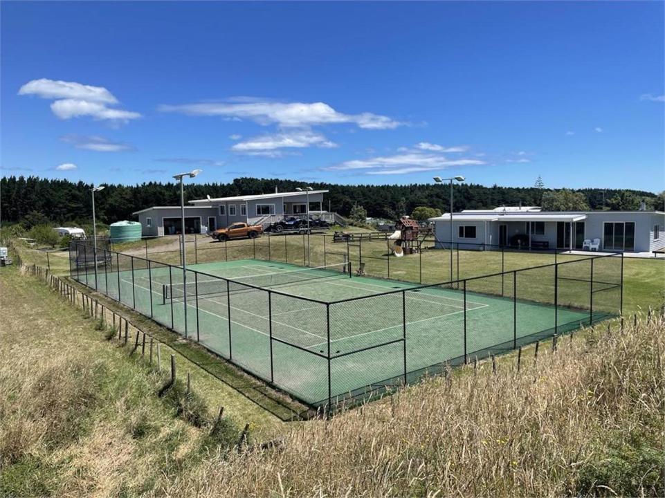 a tennis court in the middle of a field at Hydrabad Views in Waitarere