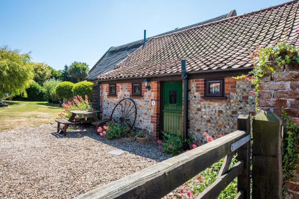 a brick cottage with a green door and a bench at 2 Bed in Bacton oc-712 in Bacton