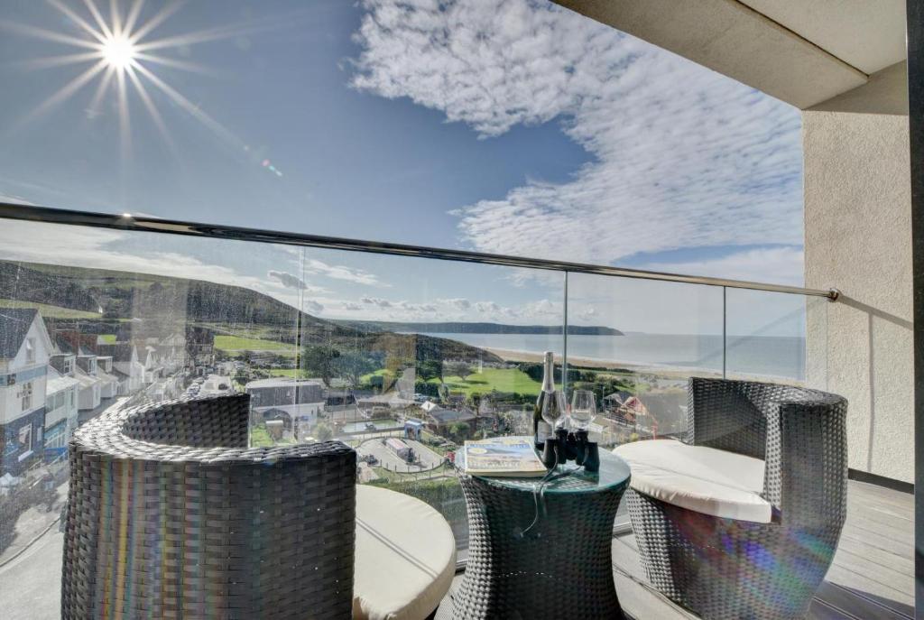 a balcony with chairs and a view of the ocean at 3 Bed in Woolacombe oc-5byron in Woolacombe