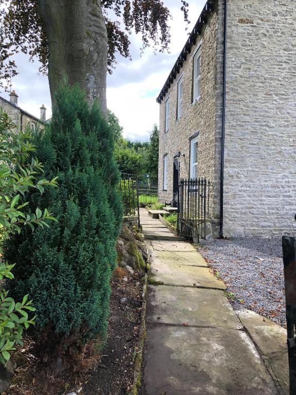 a sidewalk next to a brick building with a tree at 4 Bed in Gayle oc-ds950 in Hawes