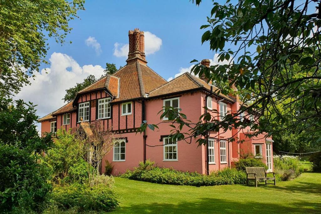 a large pink house with a chimney on a lawn at 6 Bed in Wymondham oc-t30598 in Wymondham