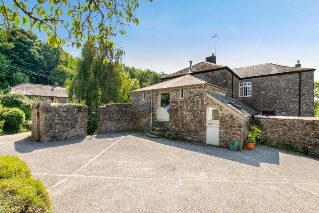 a stone house with a driveway in front of it at 1 Bed in Totnes oc-bcbove in Broadhempston