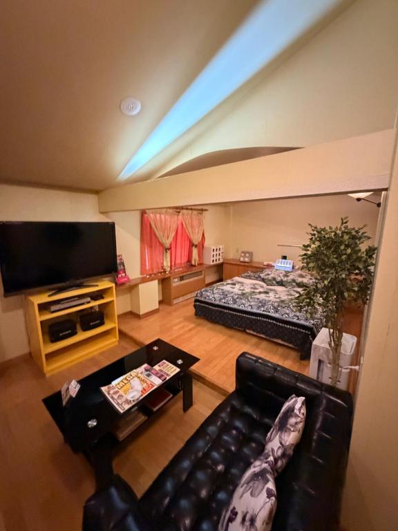 a living room with a couch and a bed at ホテルプチハウス大人専用 in Barajima