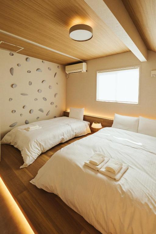a bedroom with two beds and a window at 若葉ホテル in Tokyo