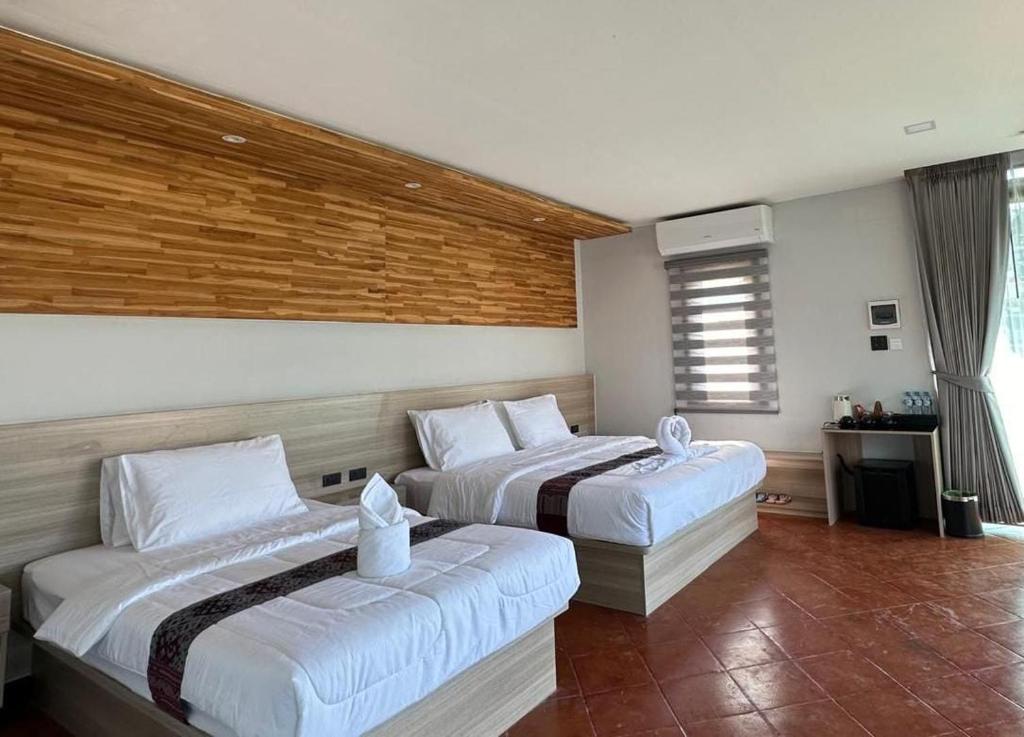 a bedroom with two beds and a window at Oasis VangVieng Resort & Cafe in Ban Naka