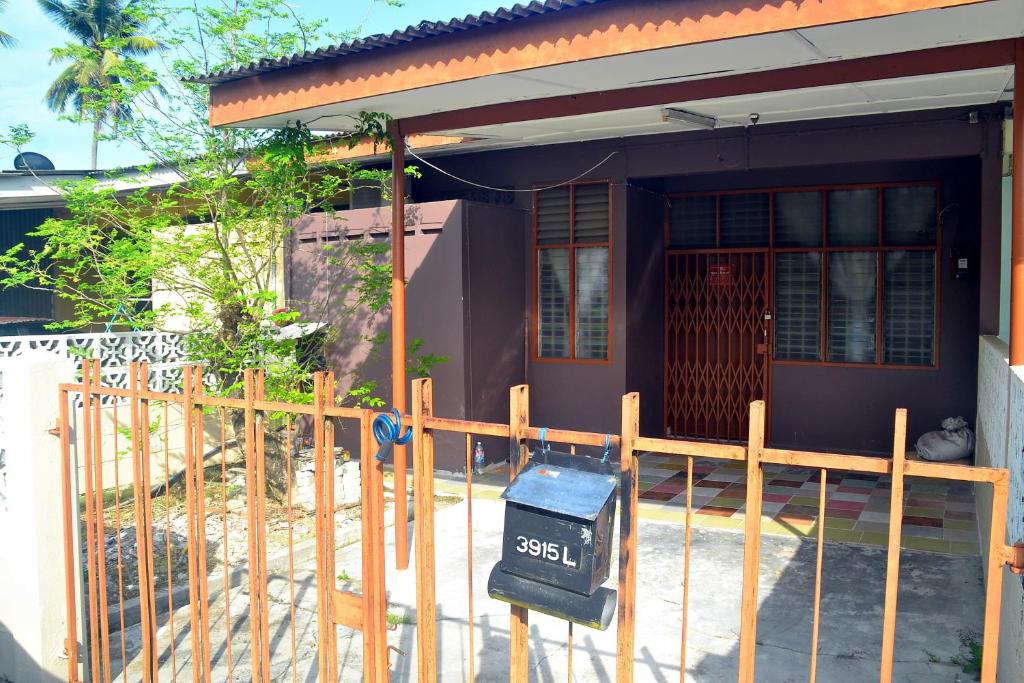 a house with a fence in front of it at Homestay Kota Bharu, Telipot in Kota Bharu