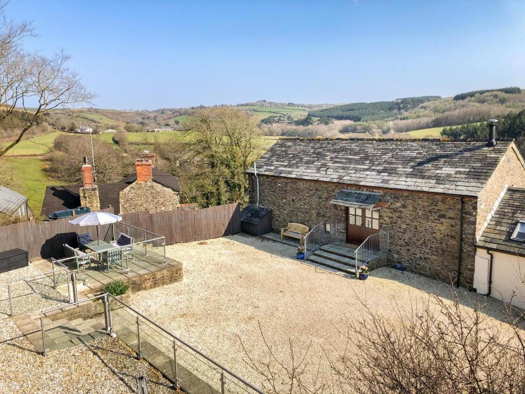 an old brick house with a patio in a yard at 3 Bed in Woodford oc-w32062 in Kilkhampton