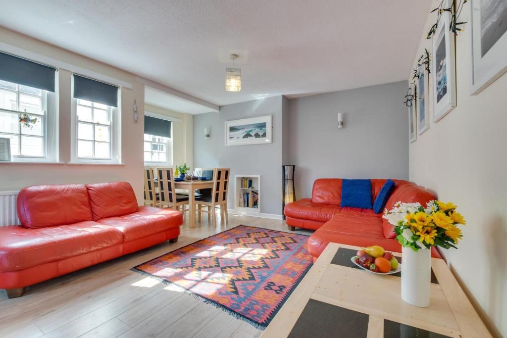 a living room with a red couch and a table at 3 Bed in St. Ives oc-virg14 in St Ives
