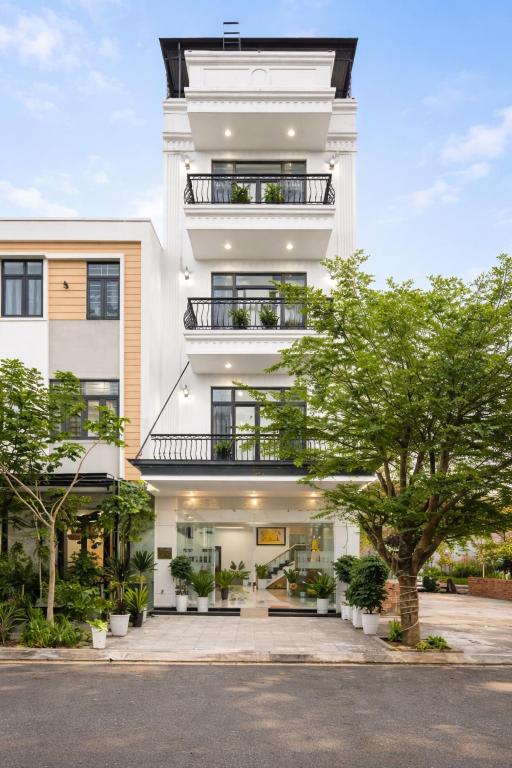 a white building with trees in front of it at Valentin Motel 2 Đà Nẵng in Danang