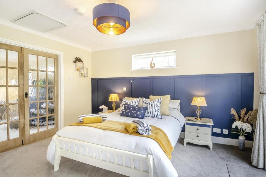 a bedroom with a large white bed and a blue wall at 1 Bed in North Walsham oc-f29380 in North Walsham