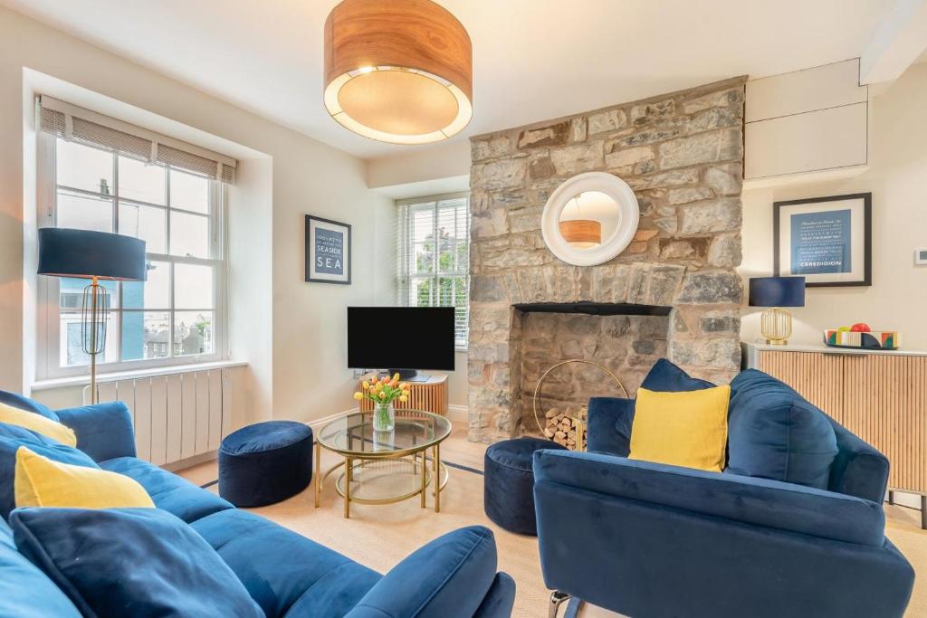 a living room with blue furniture and a stone fireplace at 3 Bed in New Quay oc-c29640 in New Quay