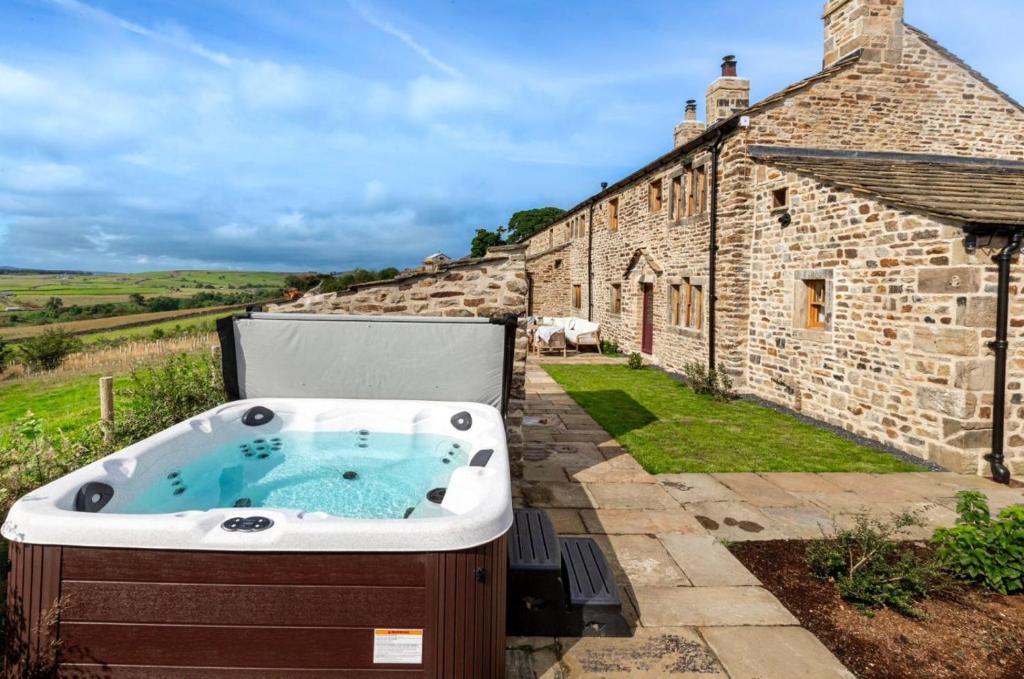 a hot tub in front of a stone building at 4 Bed in Cowling oc-h30773 in Cowling