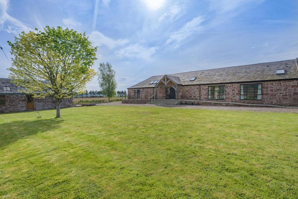 a brick house with a tree in a yard at 4 Bed in Rattray oc-e31983 in Alyth