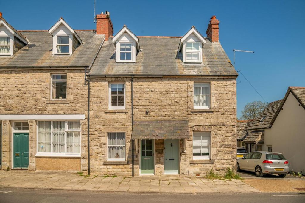 an old brick house with a car parked in front at 2 Bed in Langton Matravers oc-d28351 in Langton Matravers