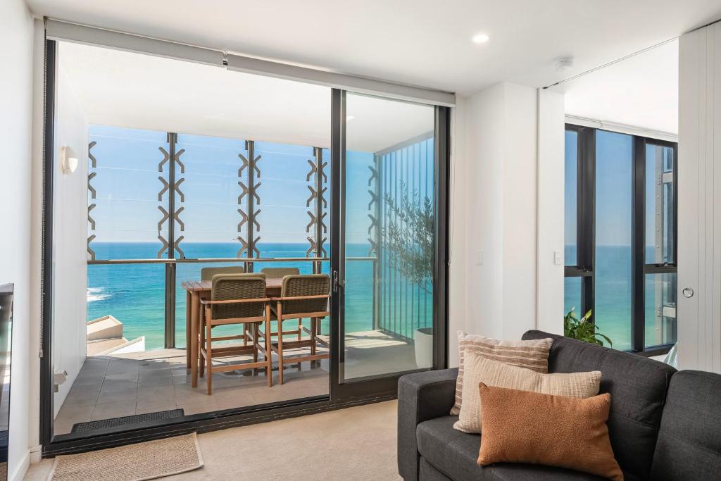 a living room with a view of the ocean at 1010 - Elite Escape - Absolute Beachfront Luxury in Newcastle