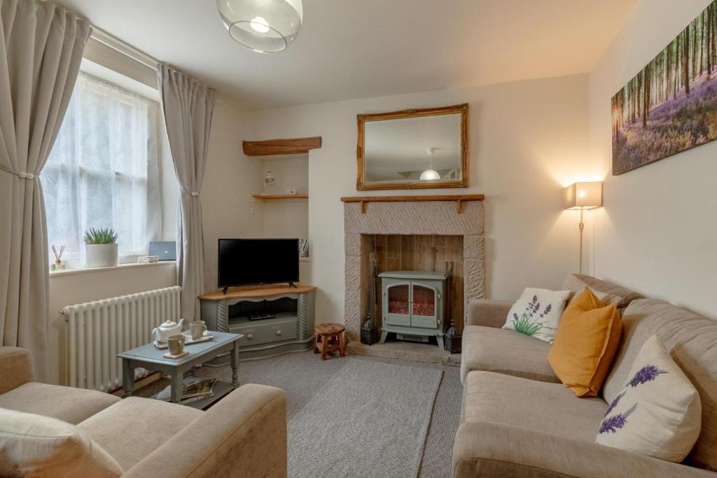 a living room with a couch and a fireplace at 3 Bed in Hope Valley oc-dcherb in Eyam