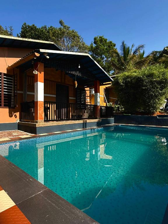 a large swimming pool in front of a house at Wayanad Cocos Villa in Tariyod