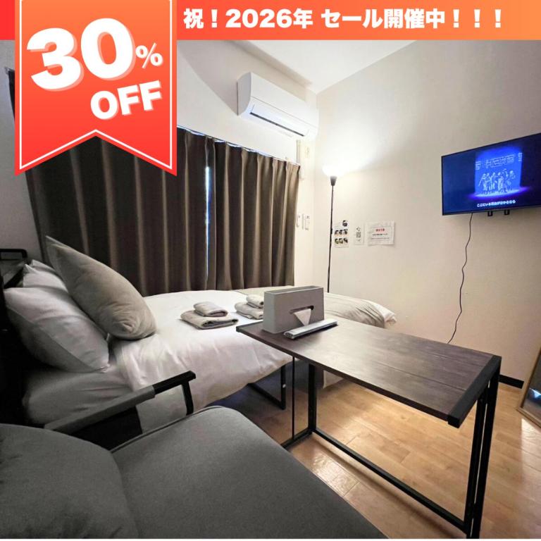 a room with a couch and a table with a laptop at メゾンド天神 in Fukuoka