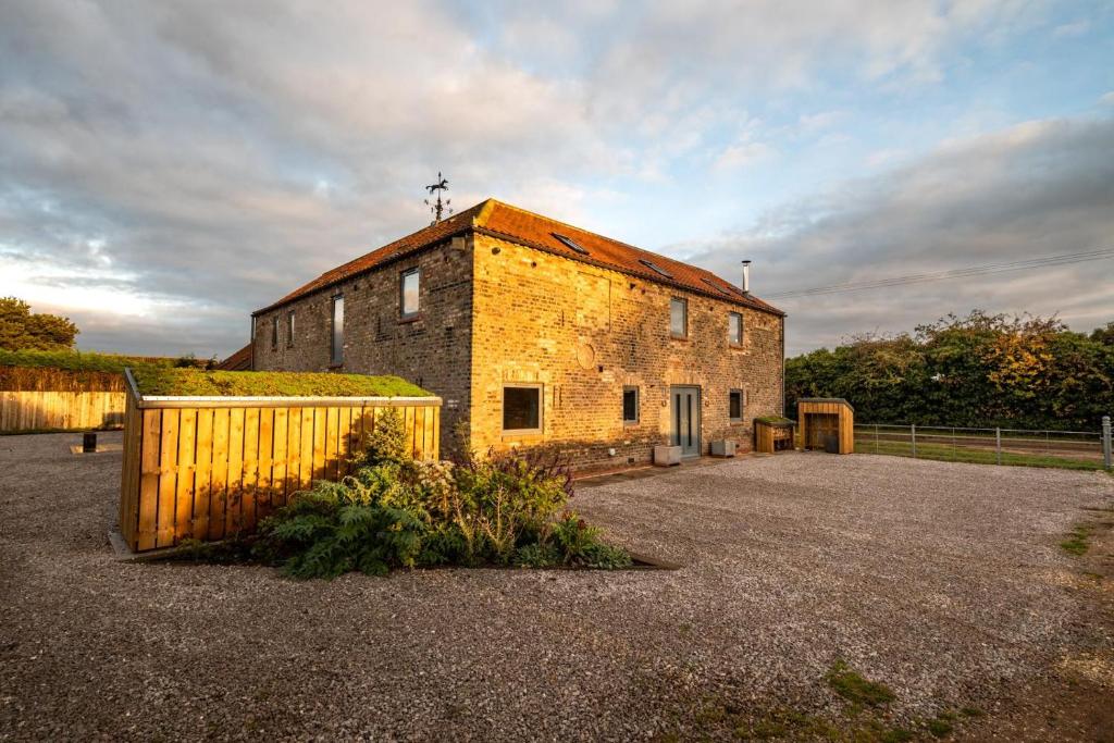 an old brick building with a cross on the roof at 7 Bed in Holme-on-Spalding-Moor oc-vy216 in Holme upon Spalding Moor