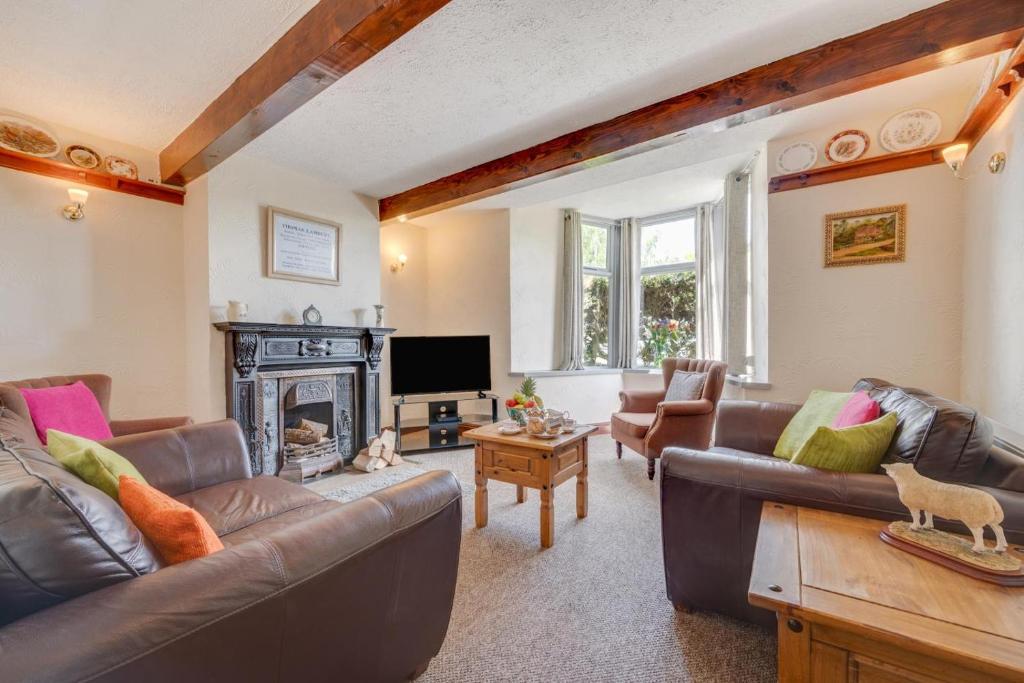 a living room with leather couches and a fireplace at 4 Bed in Hawes oc-ds940 in Hawes