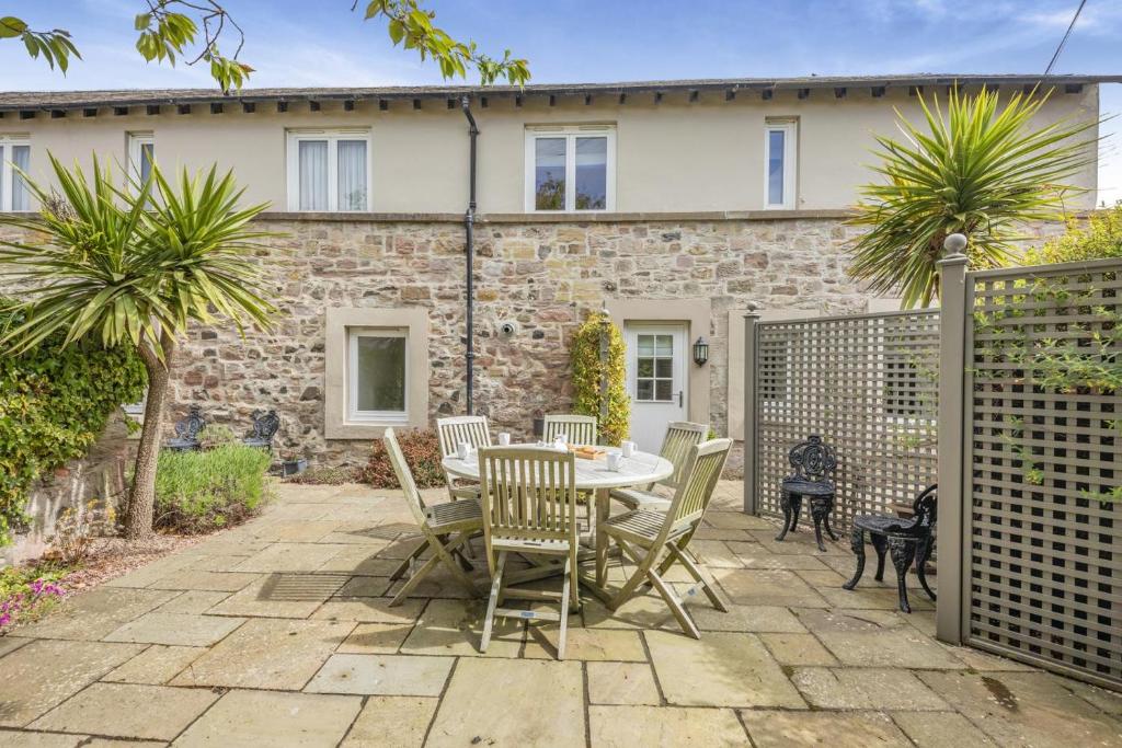 a patio with a table and chairs in front of a house at 3 Bed in Bamburgh oc-gd0468 in Bamburgh