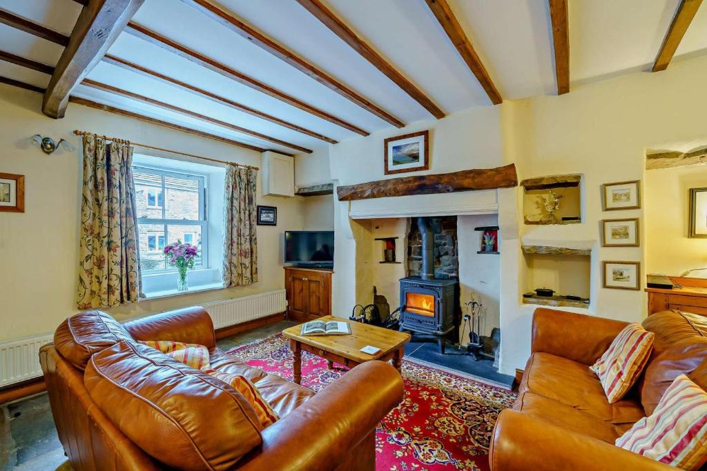 a living room with leather furniture and a fireplace at 3 Bed in Hawes oc-hhmy23 in Hawes