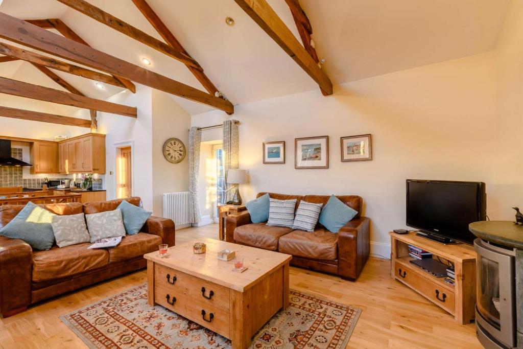a living room with a couch and a tv at 3 Bed in Warkworth oc-nb400 in Warkworth