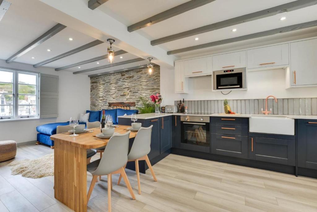 a kitchen and living room with a wooden table and chairs at 2 Bed in Padstow oc-p00876 in Padstow