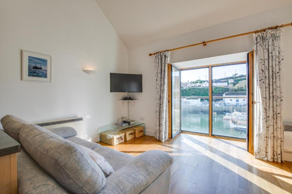 a living room with a couch and a large window at 2 Bed in Porthleven oc-quaysi in Porthleven