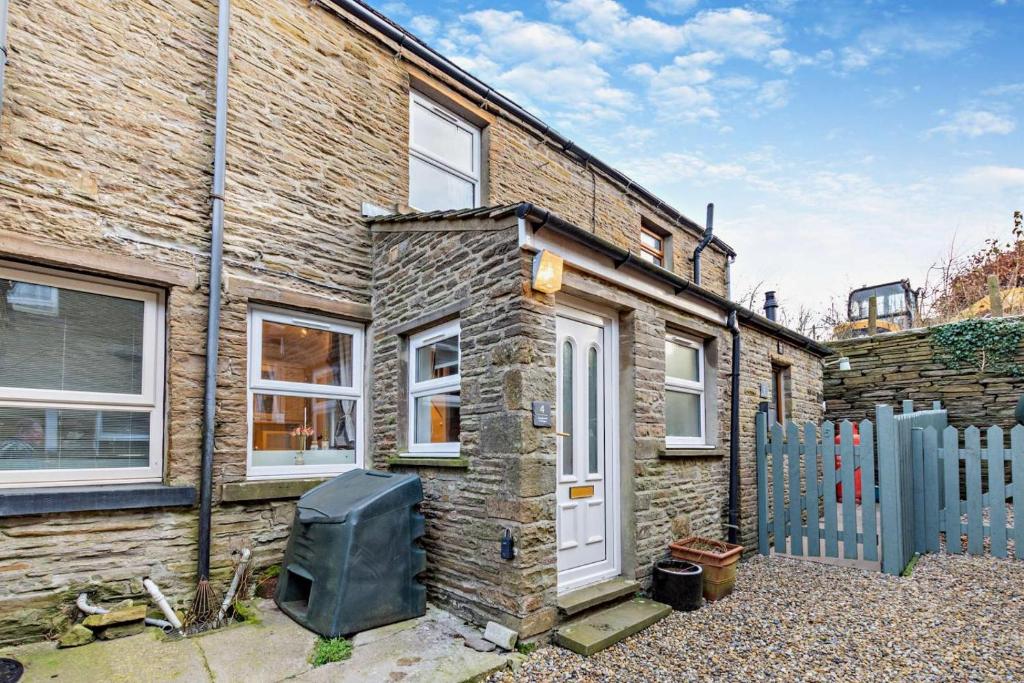 a brick house with a white door and a fence at 2 Bed in Burtersett oc-g28336 in Hawes