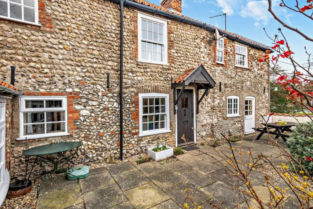 a stone house with a patio in front of it at 3 Bed in Brancaster oc-p28395 in Brancaster