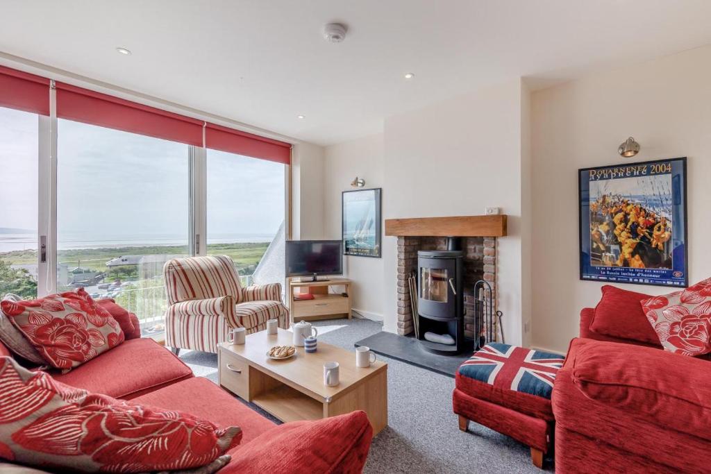 a living room with red furniture and a fireplace at 3 Bed in Aberdovey oc-v29263 in Aberdyfi