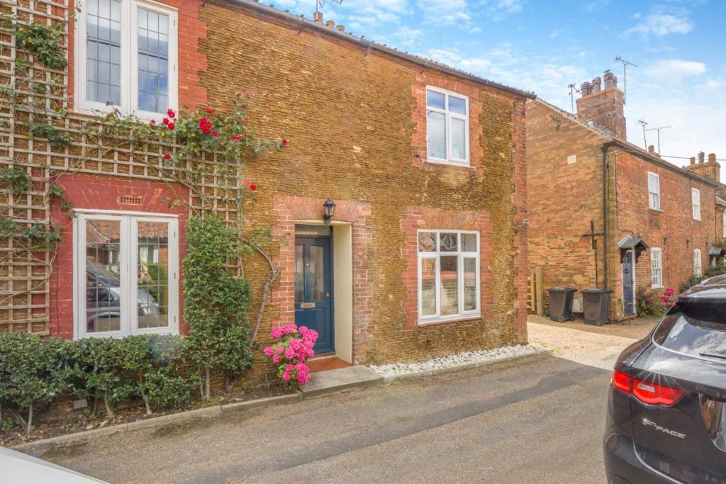 a brick building with flowers on the side of it at 2 Bed in Snettisham oc-t29559 in Snettisham