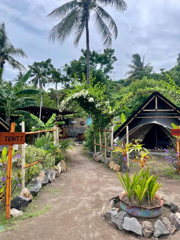ein Garten mit einigen Pflanzen und ein Gebäude in der Unterkunft Ubuntu Glamping - Adult Campers Only in Gili Trawangan