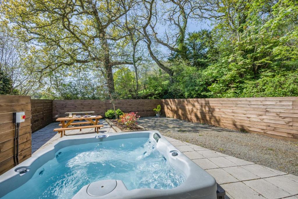 a hot tub in a backyard with a picnic table at 3 Bed in Bush oc-m31847 in Bude