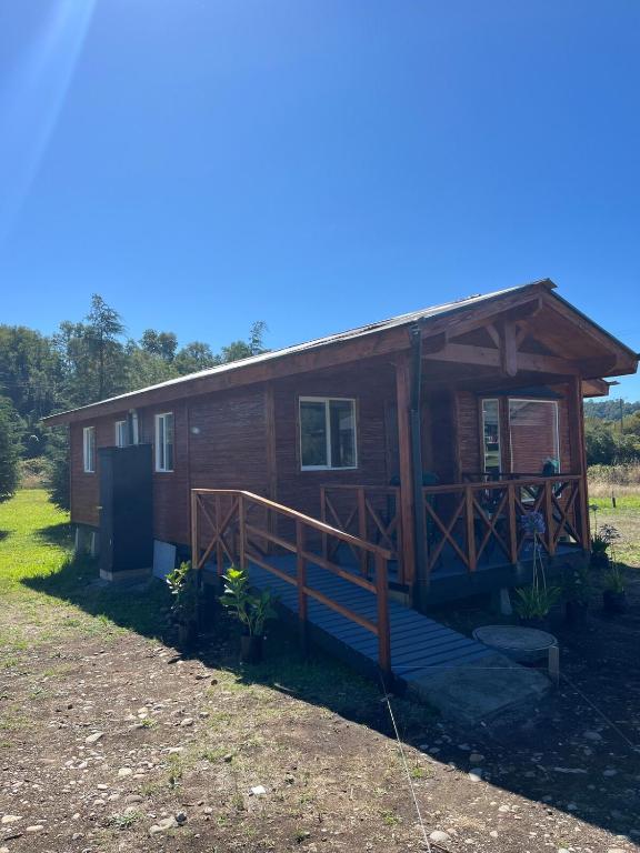 a log cabin with a porch and stairs to it at cabaña alerce lago panguipulli in Panguipulli