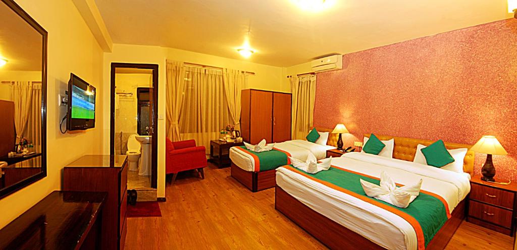 a hotel room with two beds and a television at Hotel Amaryllis in Kathmandu