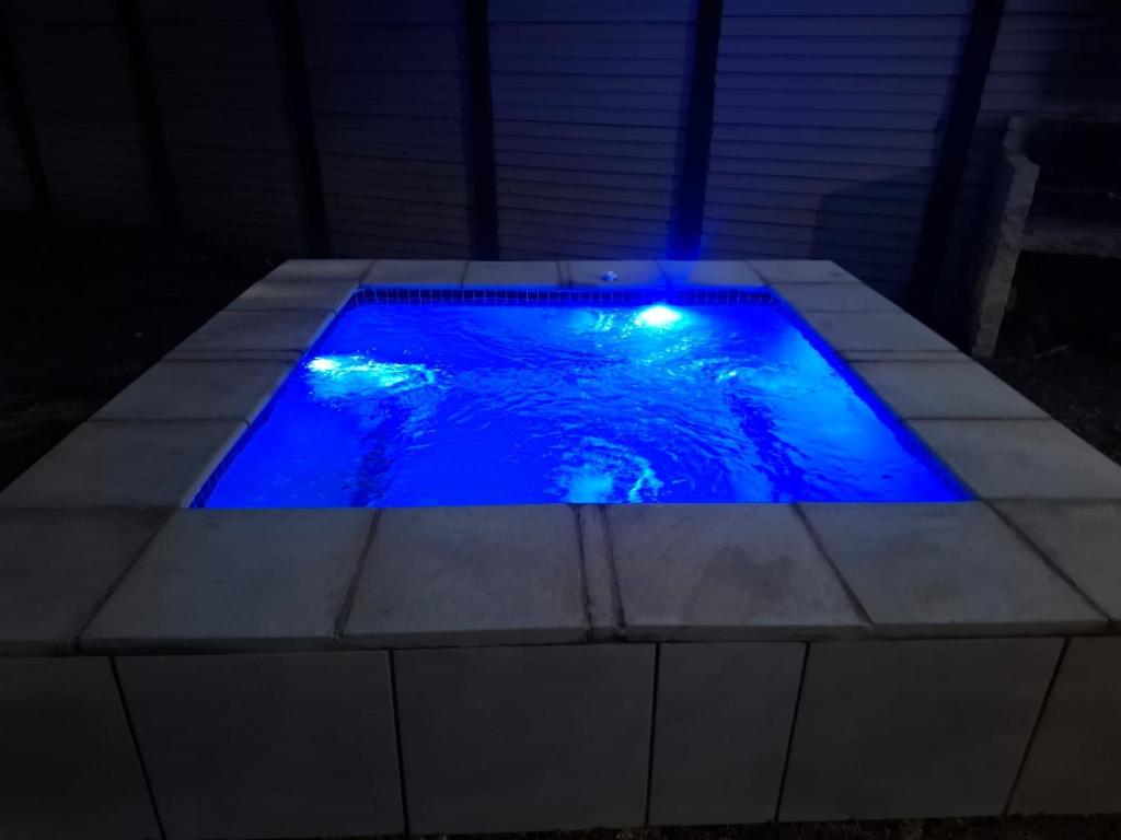 a swimming pool with blue lighting in a dark room at Adam's Inn place in Hartbeespoort