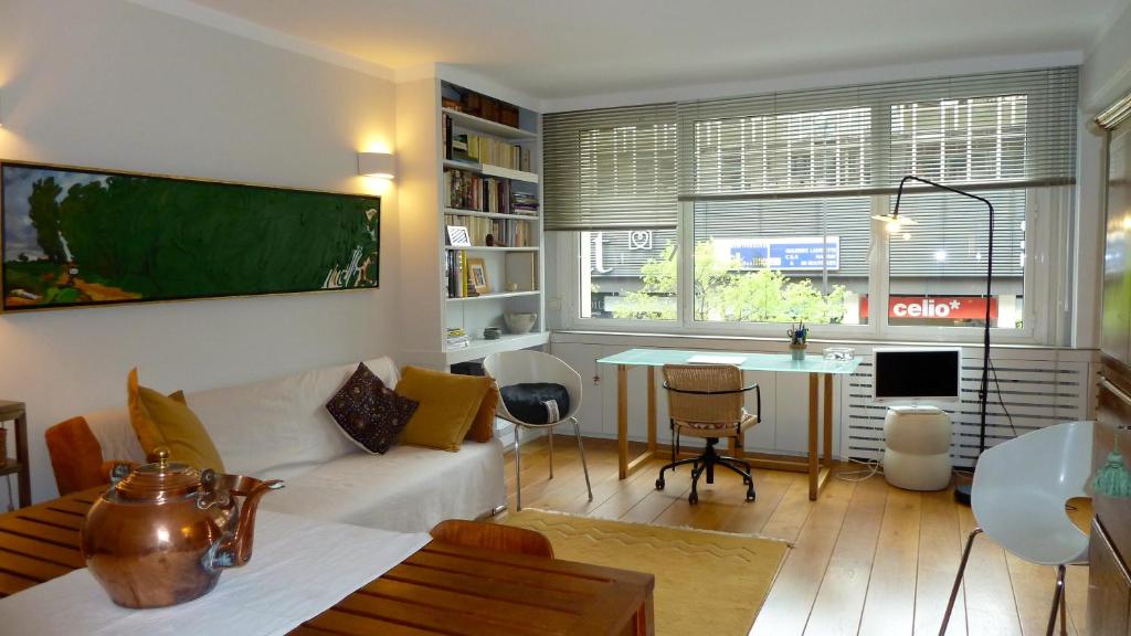 - un salon avec un canapé, une table et un bureau dans l'établissement Standing-Montparnasse, à Paris