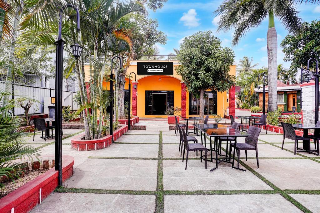a patio with tables and chairs in front of a restaurant at Townhouse Amrapali Resort in Kolhapur