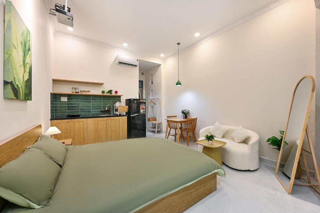 a bedroom with a large bed and a kitchen at Sai Gon Stay-Hi-Tech Park Collection in Ho Chi Minh City