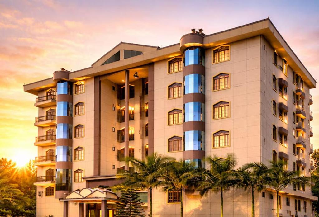 a building with palm trees in front of it at Hotel Rising Sun in Bacha