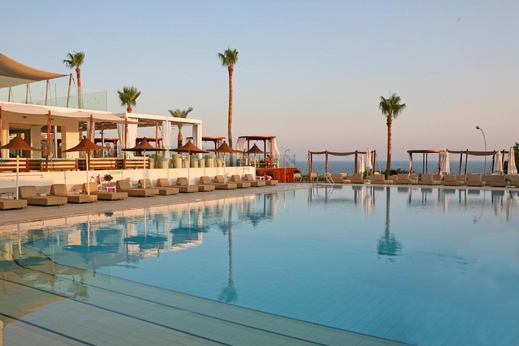 una piscina en un complejo con palmeras en Napa Mermaid Hotel & Suites, en Ayia Napa