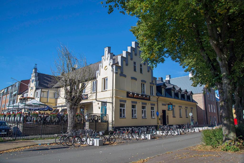 a large yellow building with bikes parked in front of it at Hotel Bishops Arms Kristianstad in Kristianstad