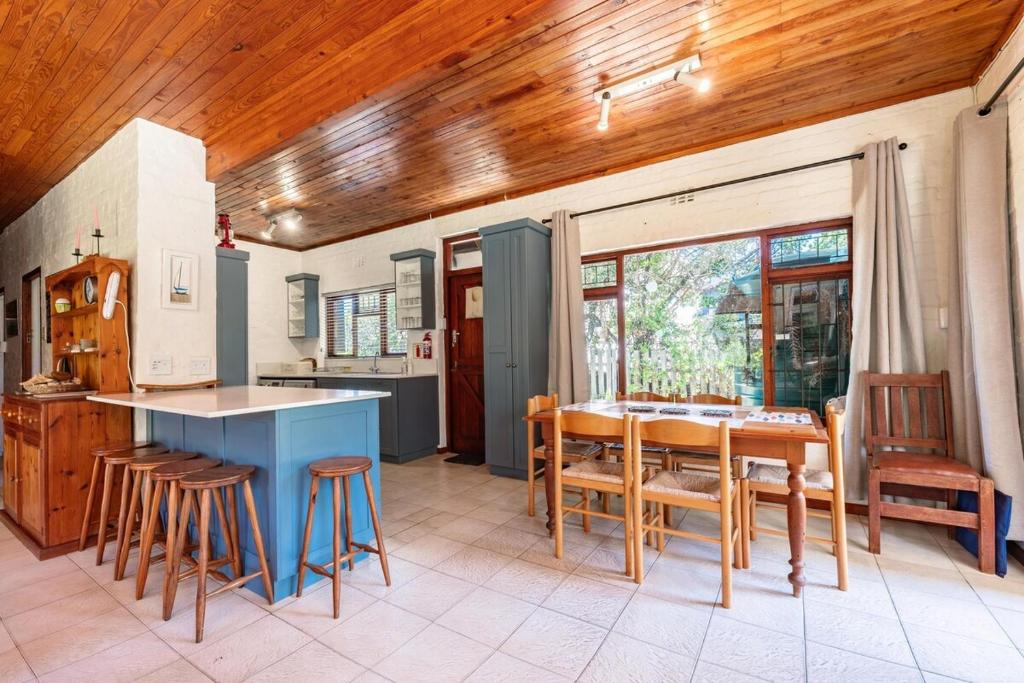 a kitchen and dining room with a table and chairs at Villa Kappri in Natureʼs Valley
